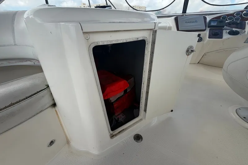 Slide: The Image of Open storage compartment on 2008 Meridian 391 Sedan boat with visible red life jacket. - 21
