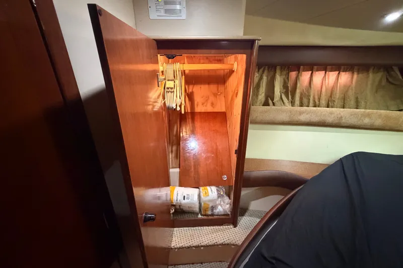 Slide: The Image of Open wooden closet inside 2008 Meridian 391 Sedan yacht, featuring hangers and storage space. - 65