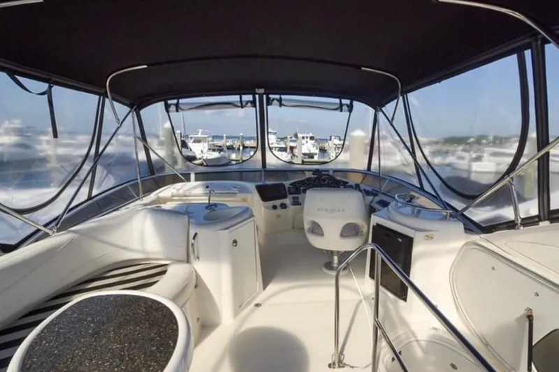 Slide: The Image of 2008 Meridian 391 Sedan yacht interior with helm, seating, and marina view. - 4