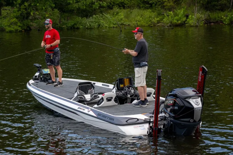 Slide: The Image of Manufacturer Provided Image: Two people fishing on a 2024 Skeeter FXR21 Apex boat in a serene lake. - 13