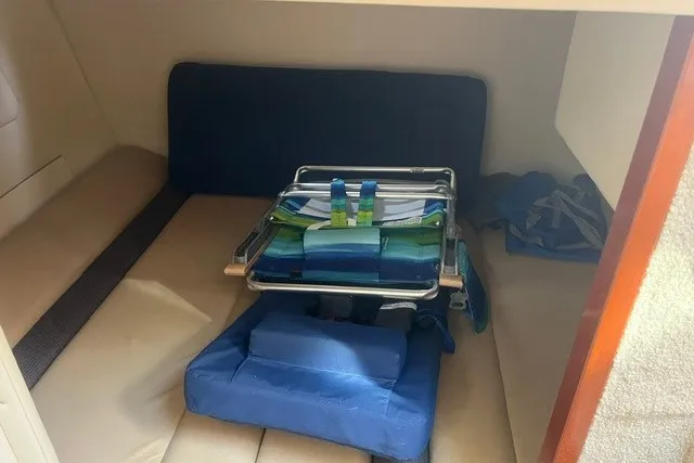 Slide: The Image of Interior cabin of 2006 Maxum 3300 SE boat with folded beach chairs and cushions. - 17