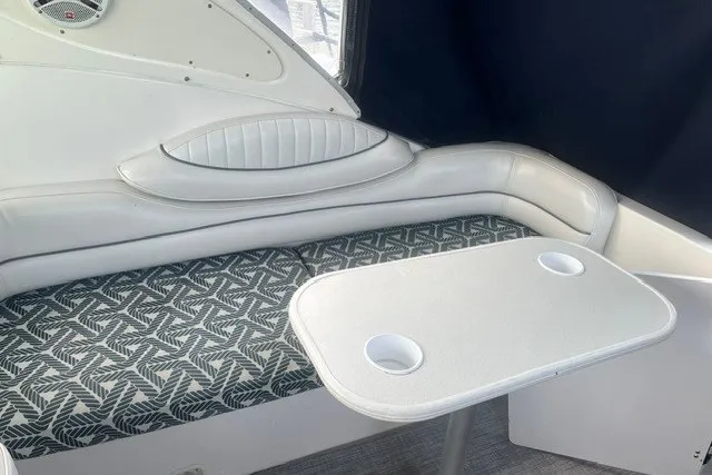 Slide: The Image of 2006 Maxum 3300 SE boat interior with patterned seating and a white table. - 5