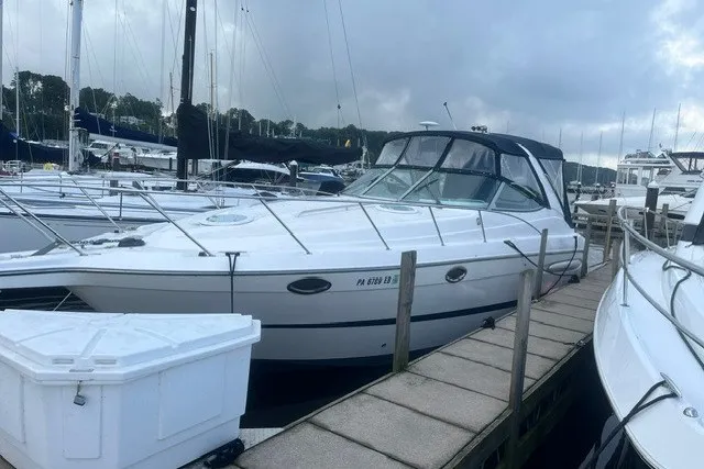 The Image of 2006 Maxum 3300 SE boat docked at marina under cloudy sky. - 1