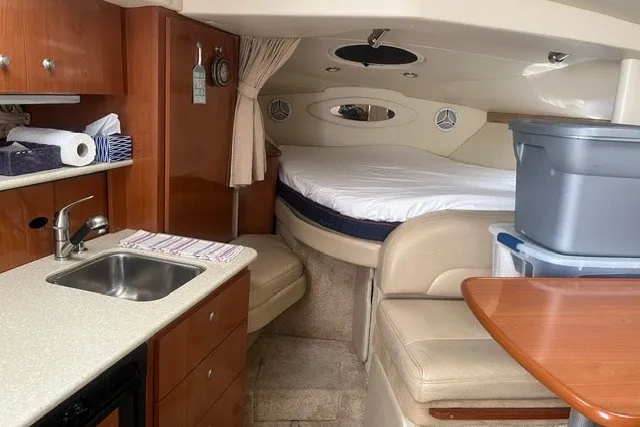 Slide: The Image of 2006 Maxum 3300 SE cabin interior with kitchenette, seating, and bed. - 19
