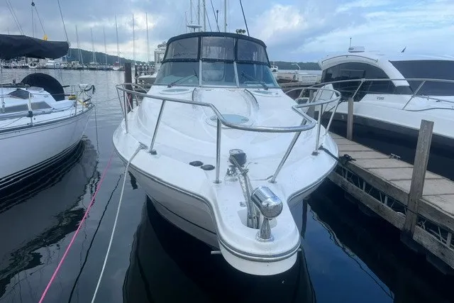 Slide: The Image of 2006 Maxum 3300 SE boat docked at marina, front view with clear sky. - 2