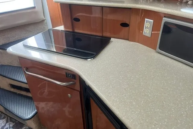 Slide: The Image of 2006 Maxum 3300 SE yacht kitchen with sleek countertop and modern appliances. - 15