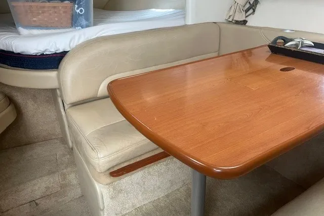 Slide: The Image of 2006 Maxum 3300 SE interior with wooden table and beige seating. - 16