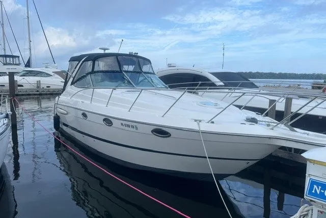 Slide: The Image of 2006 Maxum 3300 SE boat docked at marina under cloudy sky. - 3