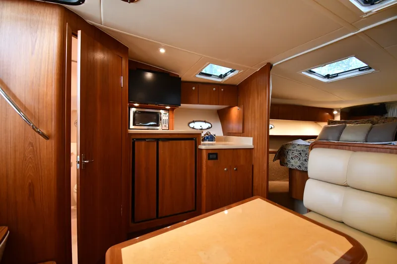 Slide: The Image of Luxurious interior of 2004 Tiara Yachts 3500 Open, featuring wood cabinetry and cozy seating. - 32