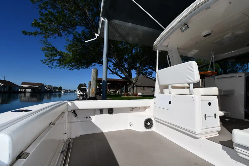 Slide: The Image of 2004 Tiara Yachts 3500 Open boat interior with seating, docked by a serene waterfront. - 18