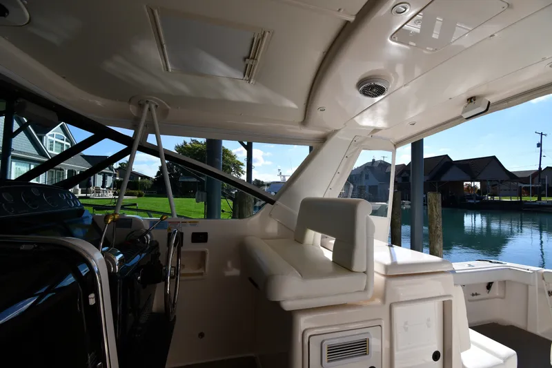 Slide: The Image of 2004 Tiara Yachts 3500 Open interior with waterfront view, showcasing helm and seating area. - 15