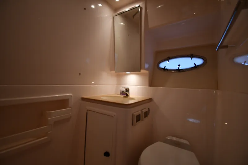 Slide: The Image of 2004 Tiara Yachts 3500 Open bathroom with sink, mirror, and porthole window. - 41