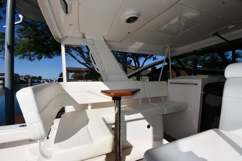 Slide: The Image of 2004 Tiara Yachts 3500 Open interior with white seating and wooden table. - 16