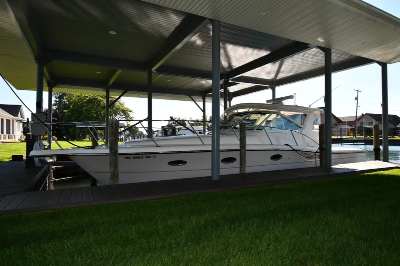 The Image of 2004 Tiara Yachts 3500 Open docked under a covered marina, surrounded by greenery. - 0