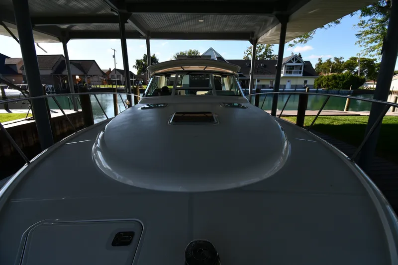 Slide: The Image of 2004 Tiara Yachts 3500 Open docked under a covered marina with waterfront view. - 5