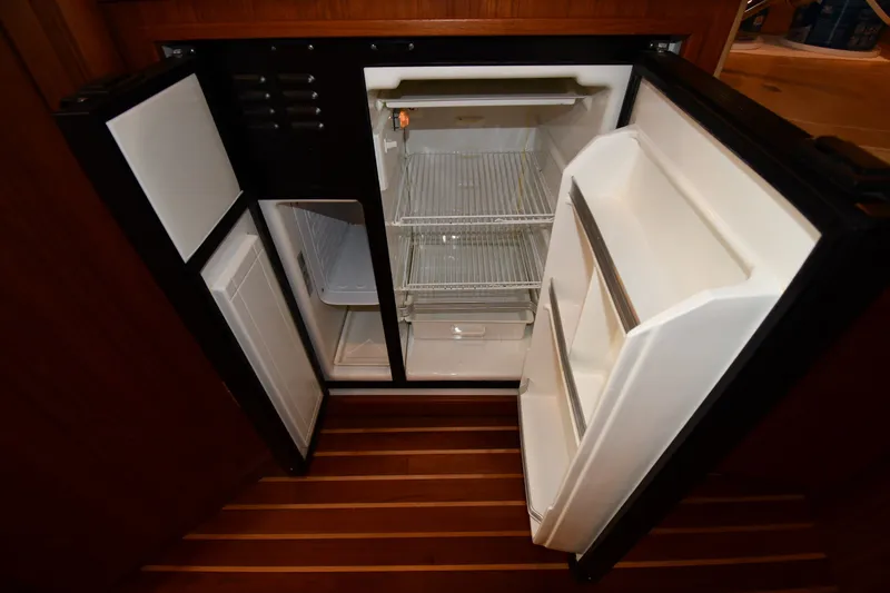 Slide: The Image of Open refrigerator inside 2004 Tiara Yachts 3500 Open, showcasing interior shelving and storage. - 39