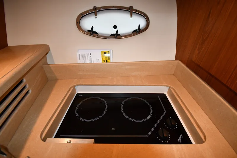Slide: The Image of 2004 Tiara Yachts 3500 Open kitchen with modern stovetop and porthole window. - 35