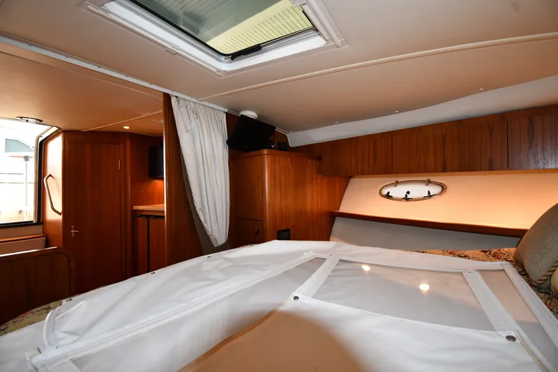 Slide: The Image of Interior cabin of 2004 Tiara Yachts 3500 Open, featuring wood paneling and a skylight. - 29