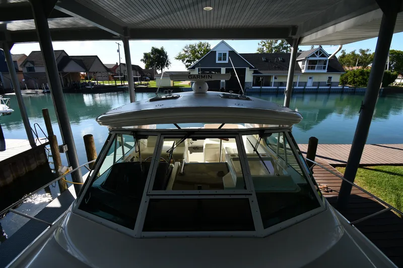 Slide: The Image of 2004 Tiara Yachts 3500 Open docked in a serene waterfront setting. - 6