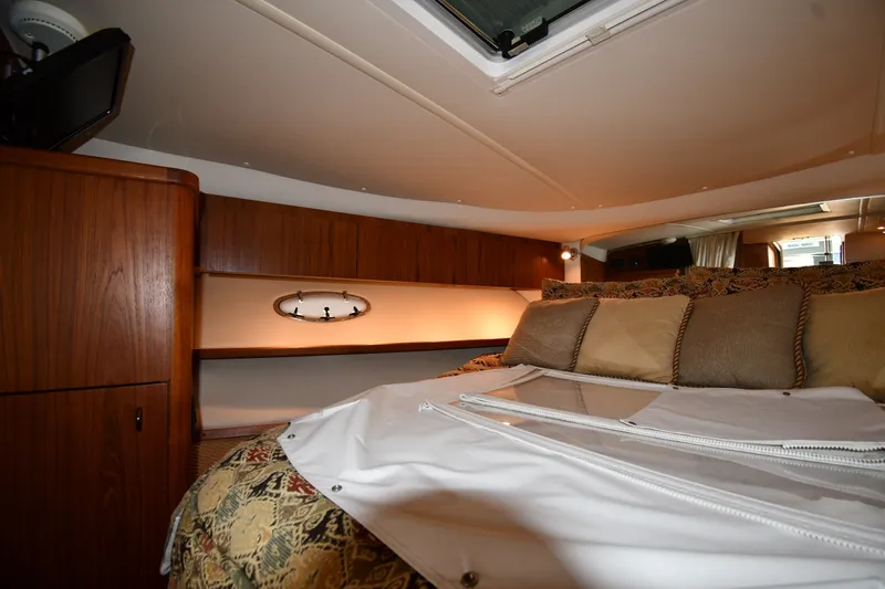 Slide: The Image of Interior cabin of 2004 Tiara Yachts 3500 Open, featuring cozy bedding and wooden cabinetry. - 28