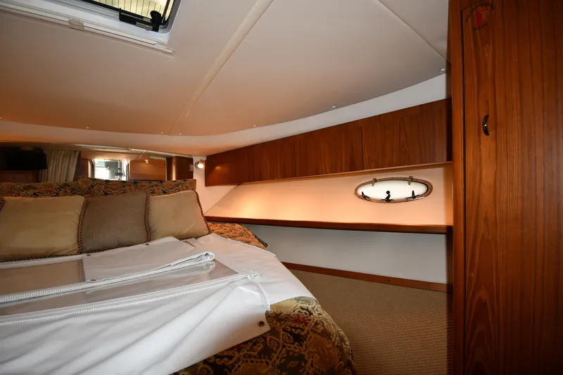 Slide: The Image of 2004 Tiara Yachts 3500 Open cabin interior with wood paneling and cozy bedding. - 27
