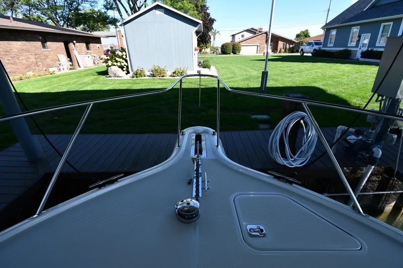 Slide: The Image of 2004 Tiara Yachts 3500 Open bow view with dock and garden background. - 3