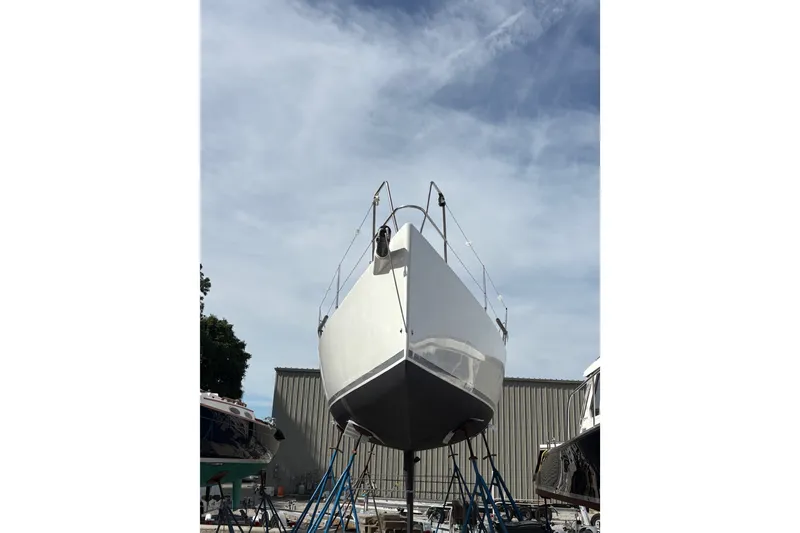Slide: The Image of 2012 J Boats J/111 sailboat on stands under a cloudy sky. - 2