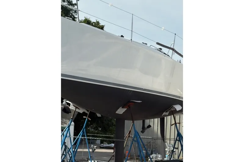 Slide: The Image of 2012 J Boats J/111 sailboat on stands, hull view, in a boatyard setting. - 5