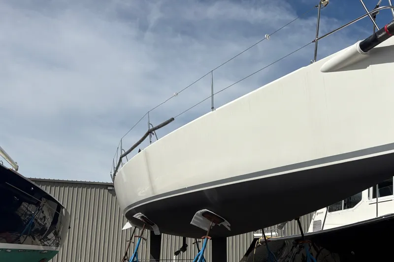 Slide: The Image of 2012 J Boats J/111 sailboat in dry dock, showcasing sleek hull design. - 3