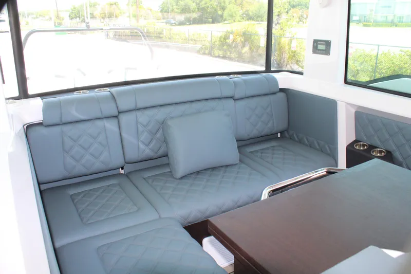 Slide: The Image of 2022 Axopar 37 XC Cross Cabin Brabus interior with blue quilted seating and table. - 48