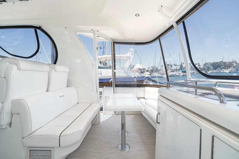 Slide: The Image of 2008 Cruisers Yachts 415 Express Motoryacht interior with white seating and marina view. - 24