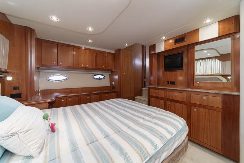 Slide: The Image of Luxurious 2008 Cruisers Yachts 415 Express Motoryacht bedroom with wood cabinetry and striped bedding. - 53