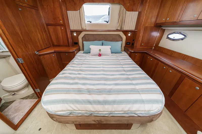 Slide: The Image of Luxurious 2008 Cruisers Yachts 415 Express Motoryacht bedroom with wood cabinetry and cozy bed. - 54