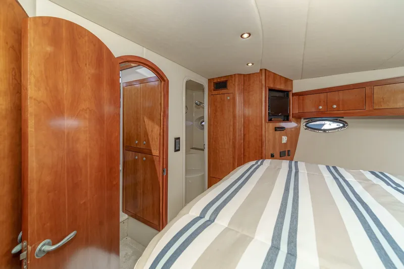 Slide: The Image of Interior of 2008 Cruisers Yachts 415 Express Motoryacht with wood cabinetry and striped bedding. - 51