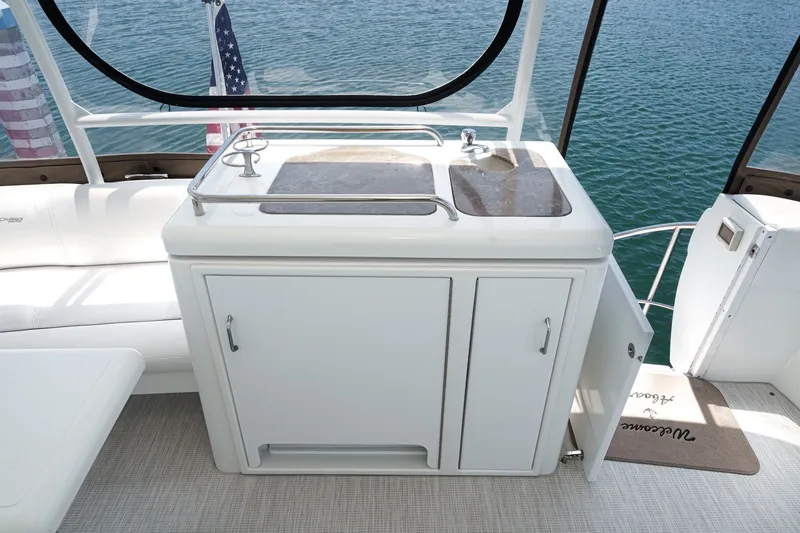 Slide: The Image of 2008 Cruisers Yachts 415 Express Motoryacht kitchenette with sink and storage, overlooking water. - 21