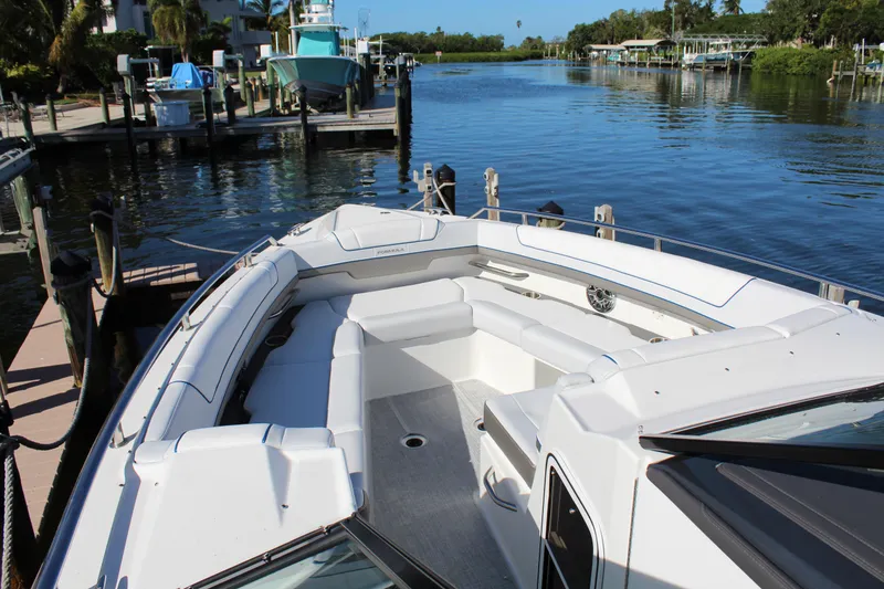 Slide: The Image of 2023 Formula 330 Crossover Bowrider docked by a serene waterfront. - 17