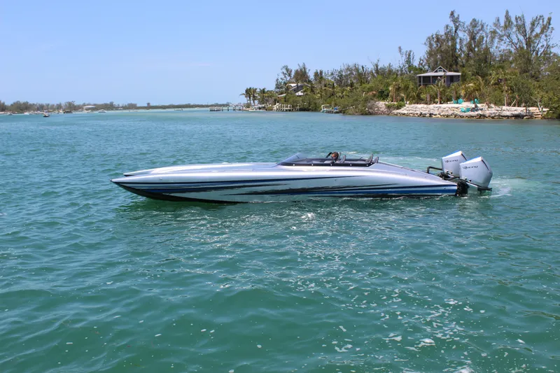 Slide: The Image of 2025 Fountain 34 Thundercat speedboat on clear blue water, near a lush shoreline. - 30