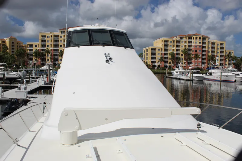 Slide: The Image of 2003 Ocean Yachts 65 Odyssey docked at marina with colorful buildings in background. - 21