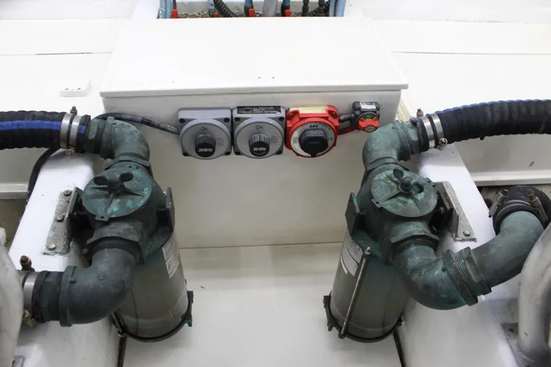 Slide: The Image of Engine room of 2003 Ocean Yachts 65 Odyssey, featuring dual water pumps and control switches. - 102