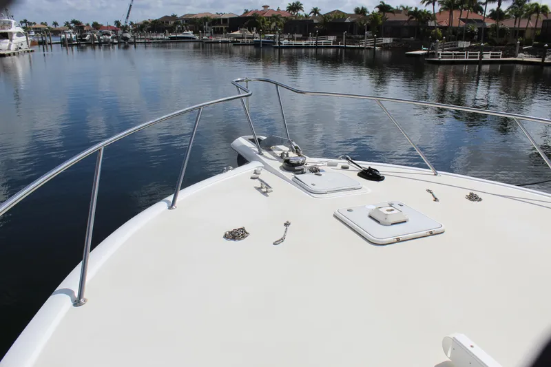 Slide: The Image of Bow view of 2003 Ocean Yachts 65 Odyssey, docked in a serene marina. - 25