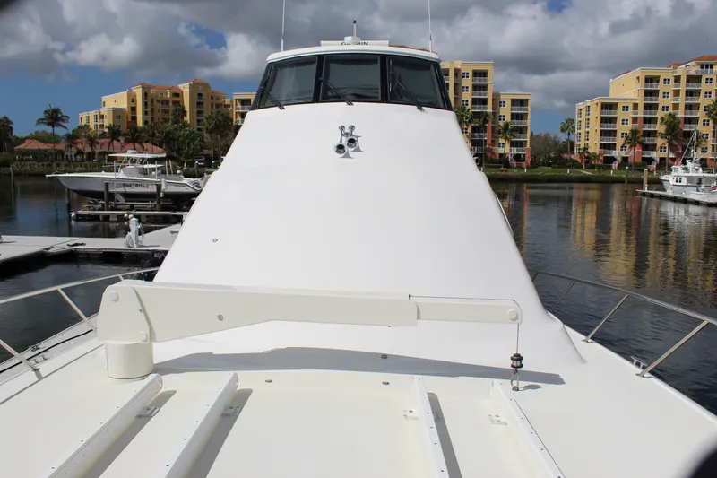 Slide: The Image of 2003 Ocean Yachts 65 Odyssey docked in a marina with waterfront buildings. - 20