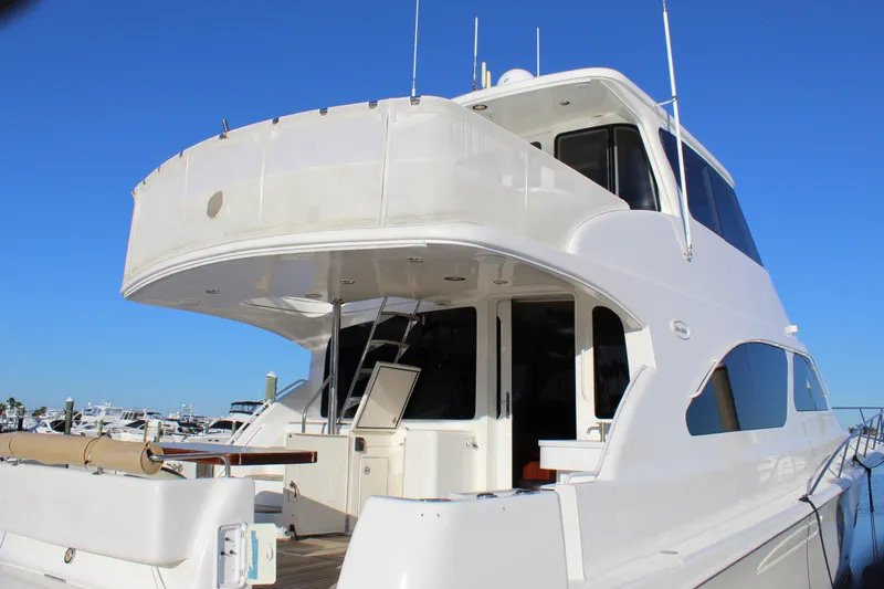Slide: The Image of 2003 Ocean Yachts 65 Odyssey, luxury yacht with sleek design, docked under clear blue sky. - 18