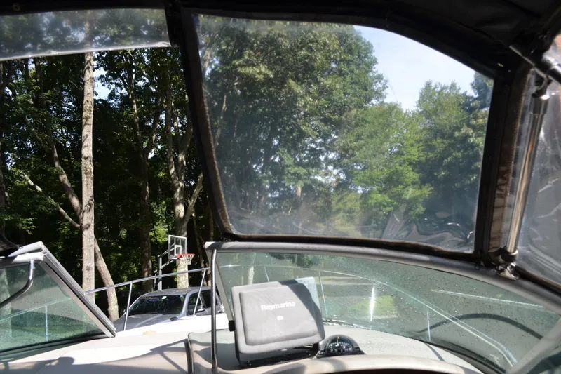 Slide: The Image of 2007 Sea Ray Sundancer 280 cockpit view with trees in the background. - 24
