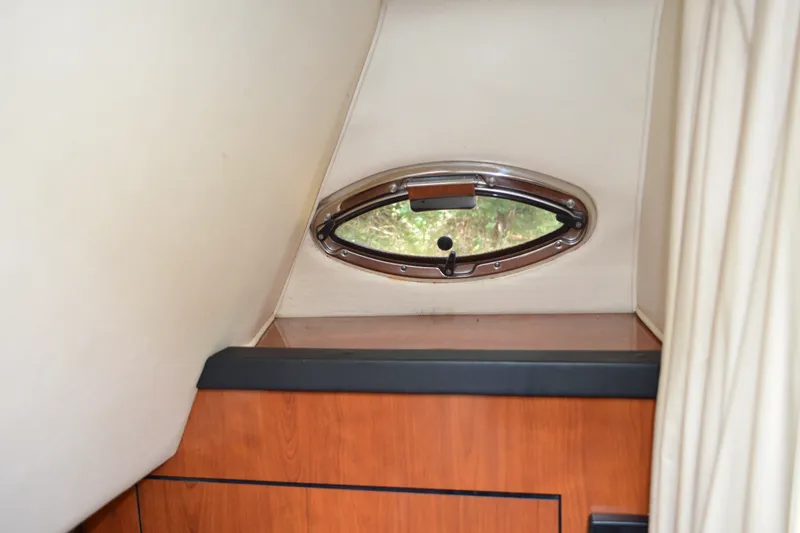 Slide: The Image of 2007 Sea Ray Sundancer 280 cabin interior with oval porthole and wooden cabinetry. - 52