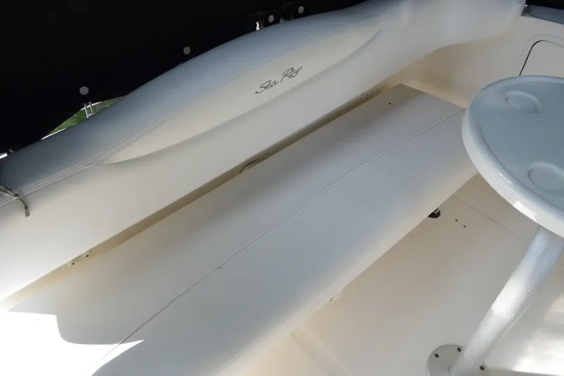 Slide: The Image of 2007 Sea Ray Sundancer 280 interior seating with white upholstery and a small table. - 19