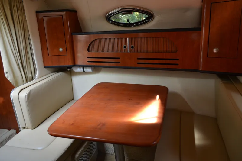 Slide: The Image of Interior of 2007 Sea Ray Sundancer 280, featuring a wooden table and seating area. - 53