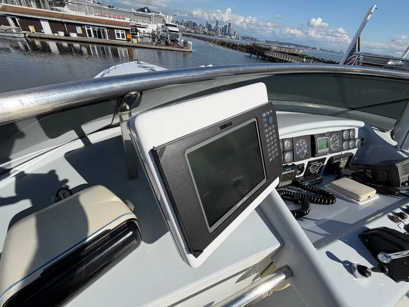 Slide: The Image of The image shows the helm of a 1990 Heisley Marine Custom 70 with a modern navigation system. - 43