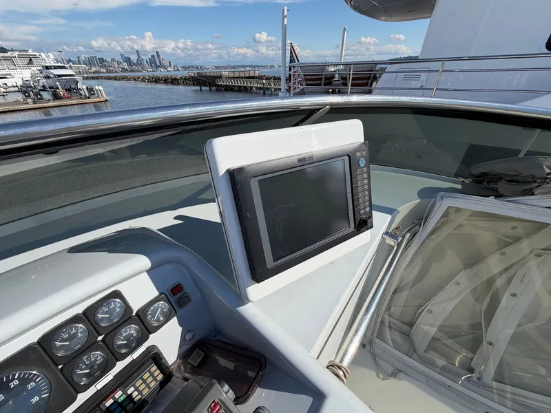 Slide: The Image of The image shows the helm of a 1990 Heisley Marine Custom 70 with a modern navigation system. - 44