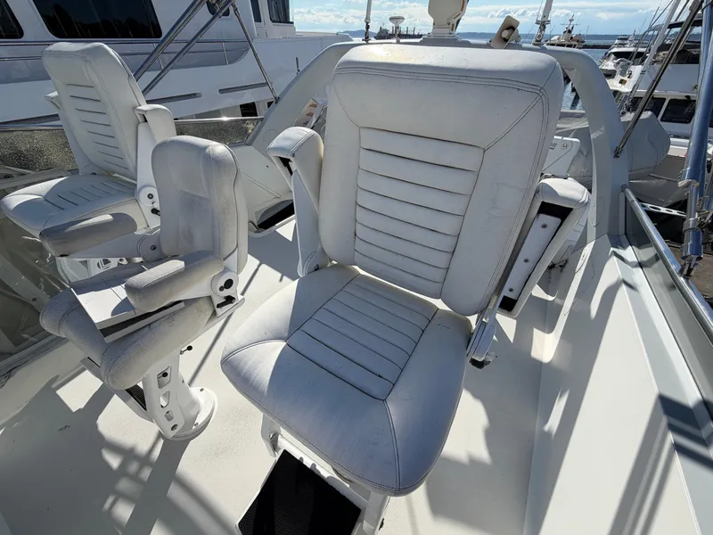 Slide: The Image of White captain's chairs on a boat deck, surrounded by other yachts in the harbor. - 47