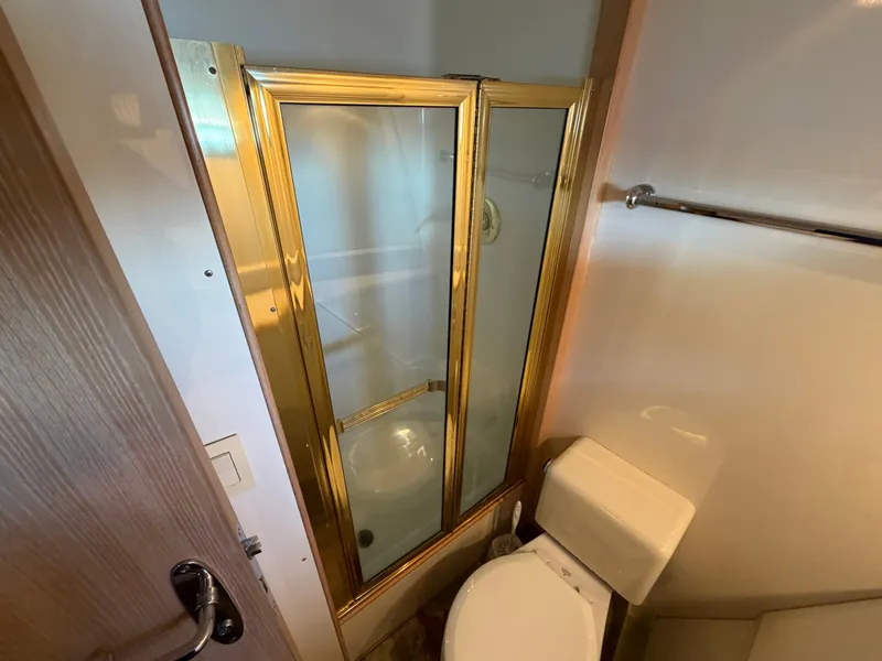 Slide: The Image of The image shows a bathroom with a gold-framed shower enclosure and a toilet. - 25